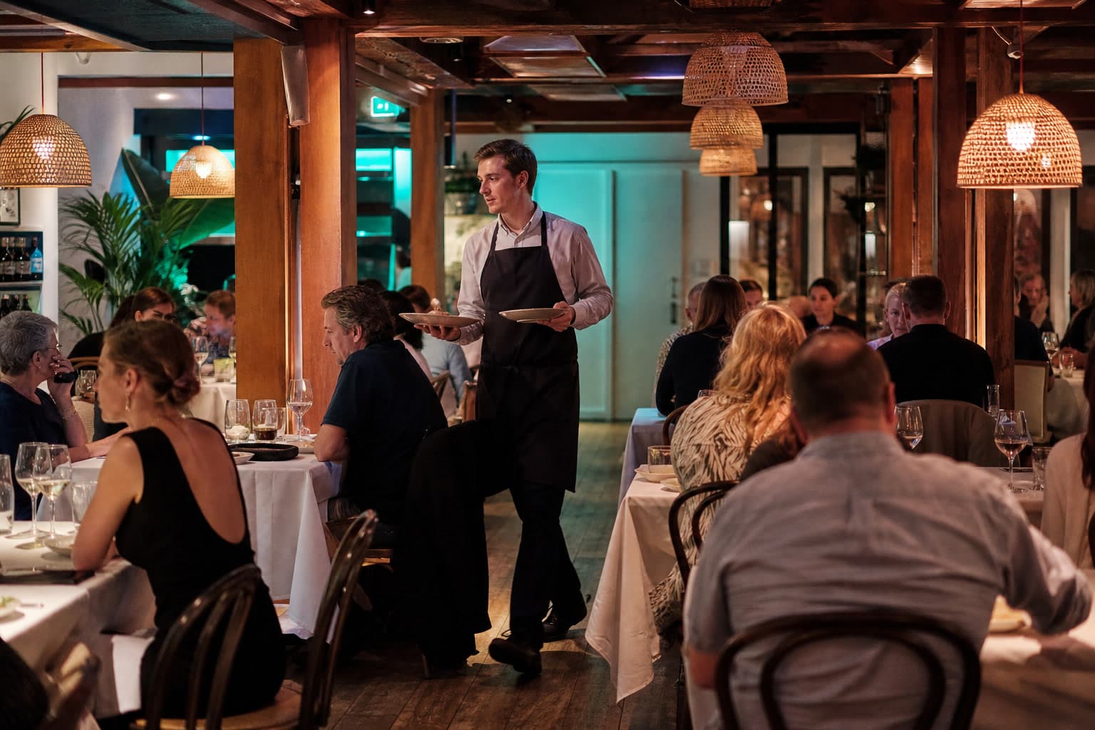 Hospitality dining room at service — the floor Hospobook is built for